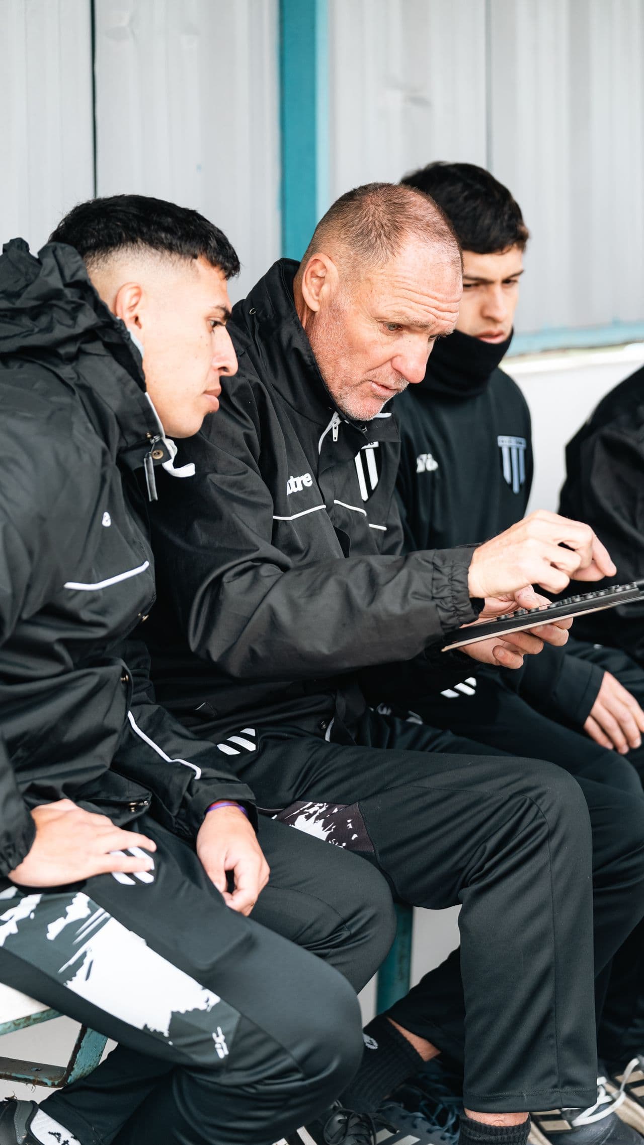 A coach reviews the squad dashboard pitchside